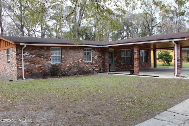 single story home with a front lawn, brick siding, and a carport