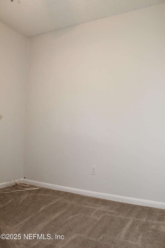 unfurnished room featuring baseboards, a textured ceiling, and carpet flooring