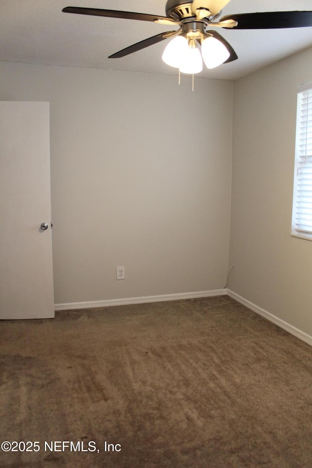 empty room featuring baseboards, carpet floors, and ceiling fan