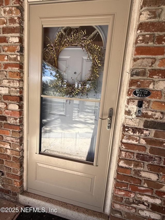 property entrance featuring brick siding