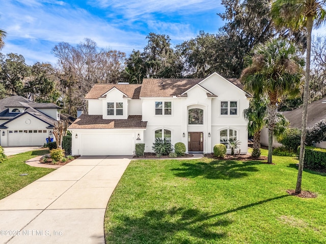 view of front of home featuring driveway, a garage, a front yard, and stucco siding