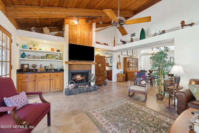 living room with a warm lit fireplace, wood ceiling, visible vents, and ceiling fan with notable chandelier