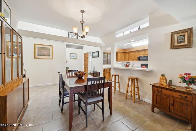 dining room with a chandelier and baseboards