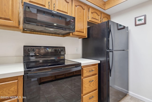 kitchen with baseboards, light countertops, black appliances, and tile patterned floors