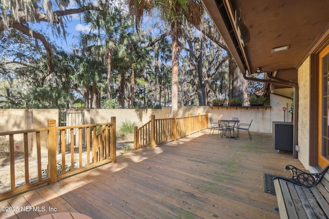 wooden terrace with outdoor dining area and fence