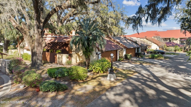 view of front facade featuring an attached garage, driveway, and a tiled roof