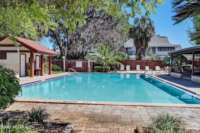 pool with a fenced backyard and a patio