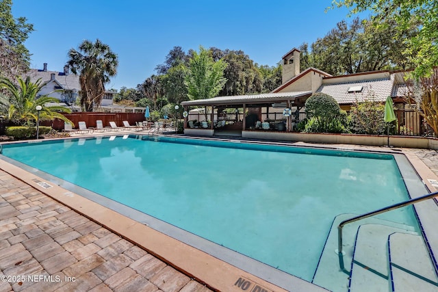 pool featuring fence and a patio