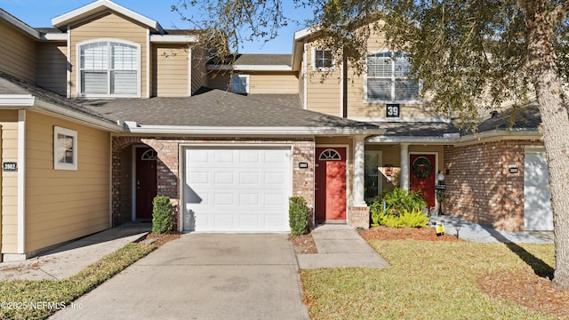 view of front of house featuring an attached garage, brick siding, driveway, and roof with shingles