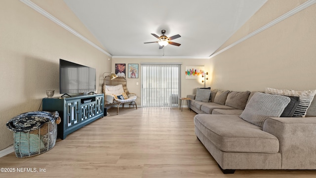 living room featuring lofted ceiling, light wood finished floors, ornamental molding, and a ceiling fan