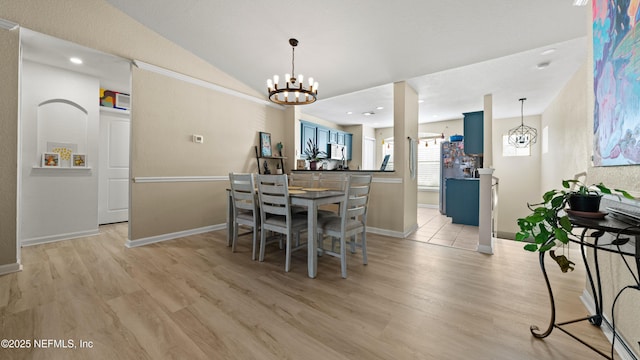 dining space with light wood-style flooring, baseboards, vaulted ceiling, and a notable chandelier