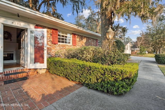 view of exterior entry featuring brick siding