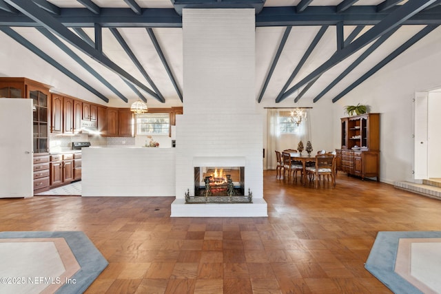 living area featuring a healthy amount of sunlight, a fireplace, and high vaulted ceiling