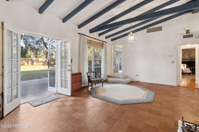 living area with high vaulted ceiling, french doors, visible vents, and a notable chandelier