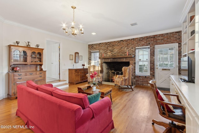 living area featuring brick wall, plenty of natural light, a fireplace, and light wood-style flooring