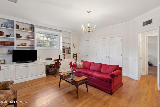 living area featuring built in desk, visible vents, crown molding, and light wood-style flooring