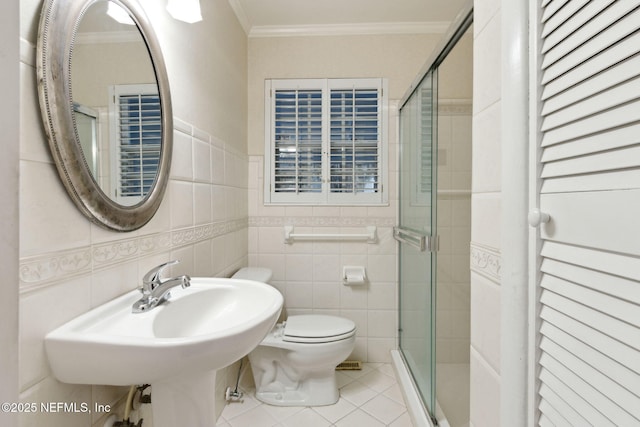 full bath with tile patterned floors, crown molding, tile walls, and a shower stall