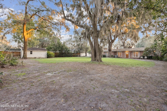 view of yard with fence and an outdoor structure