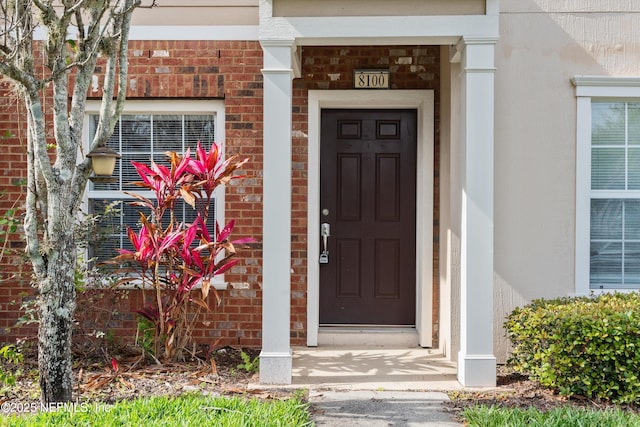 property entrance featuring brick siding