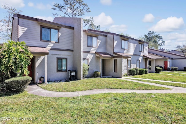 multi unit property with a front yard and stucco siding