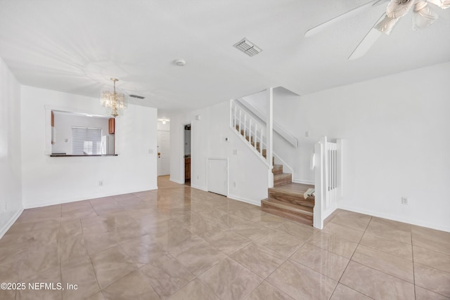 unfurnished living room with stairs, ceiling fan with notable chandelier, visible vents, and baseboards