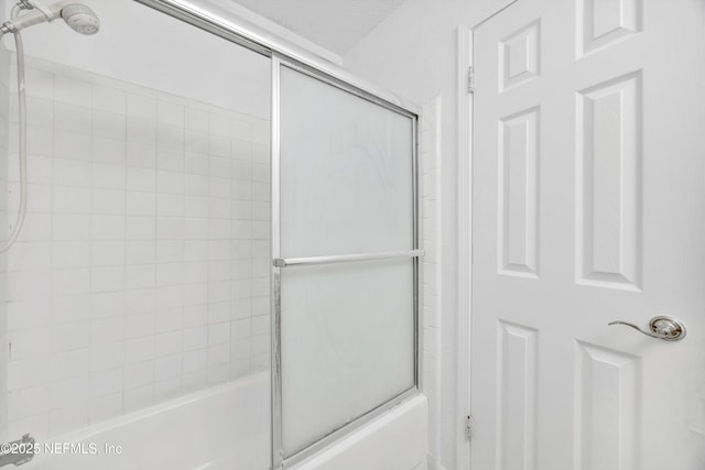 bathroom featuring bath / shower combo with glass door