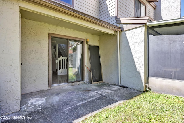 doorway to property featuring stucco siding