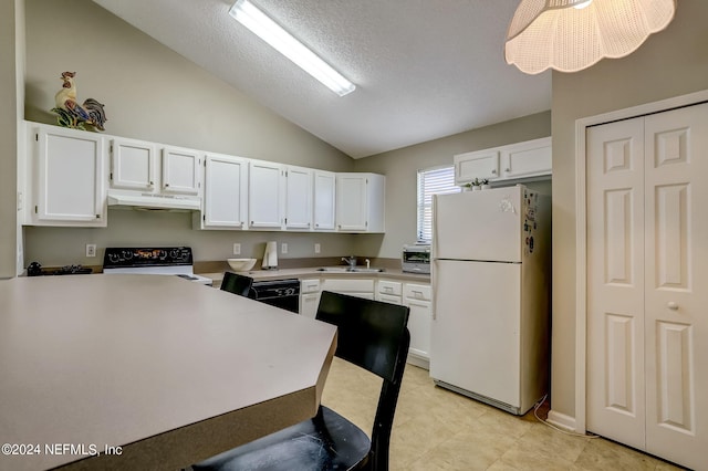 kitchen featuring under cabinet range hood, range with electric stovetop, a sink, light countertops, and freestanding refrigerator