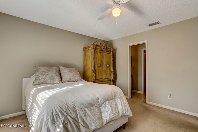 bedroom with light carpet, baseboards, visible vents, a ceiling fan, and a textured ceiling