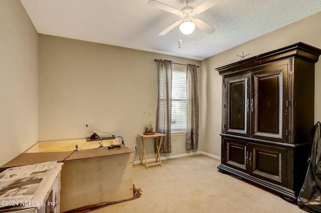 miscellaneous room featuring ceiling fan, baseboards, a textured ceiling, and light colored carpet