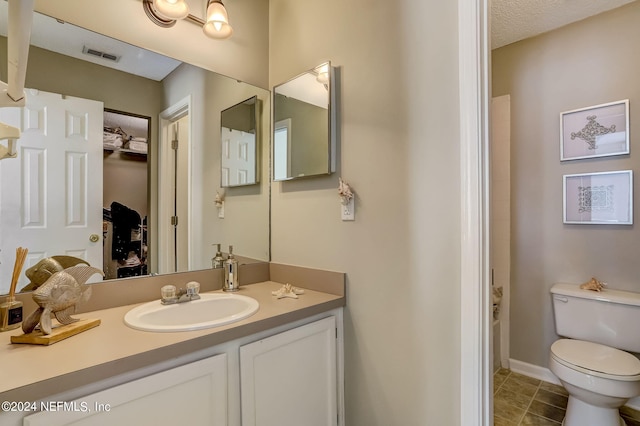 full bathroom with visible vents, toilet, tile patterned floors, walk in shower, and vanity