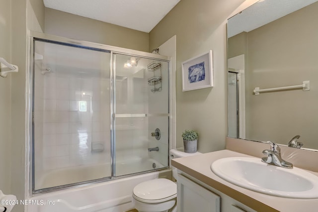 full bathroom featuring vanity, toilet, and bath / shower combo with glass door