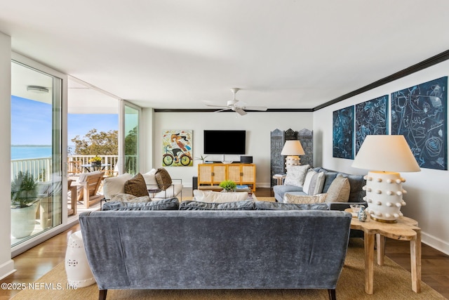 living area featuring baseboards, expansive windows, ornamental molding, and wood finished floors