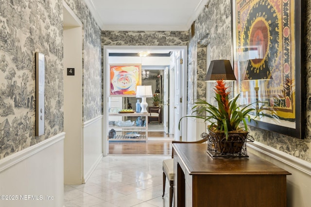 hall with ornamental molding, light tile patterned floors, wainscoting, and wallpapered walls