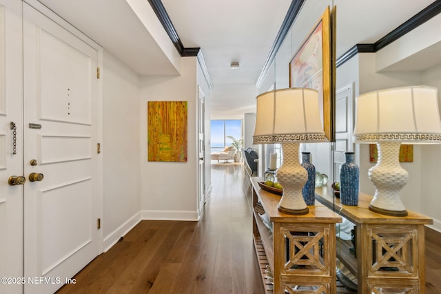 corridor featuring ornamental molding, baseboards, and dark wood-style floors