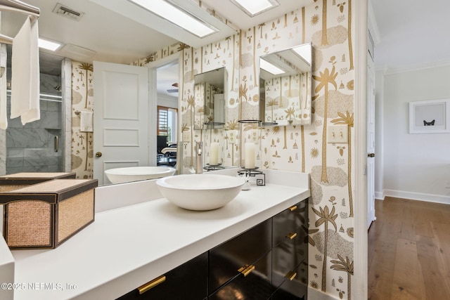 bathroom featuring visible vents, crown molding, baseboards, and wallpapered walls