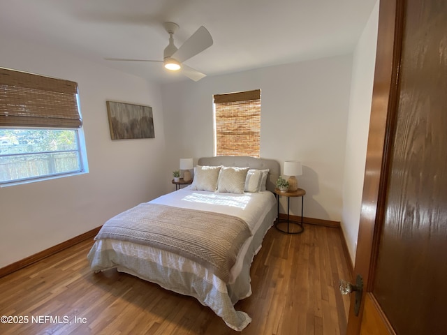 bedroom featuring a ceiling fan, baseboards, and wood finished floors