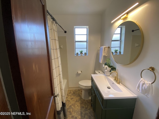 full bath featuring shower / bath combo, baseboards, vanity, and toilet