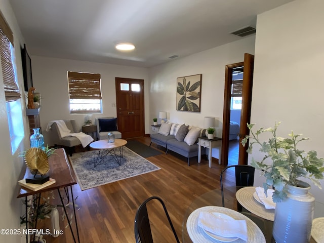 living area with visible vents and wood finished floors