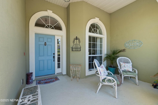 property entrance featuring a porch and stucco siding