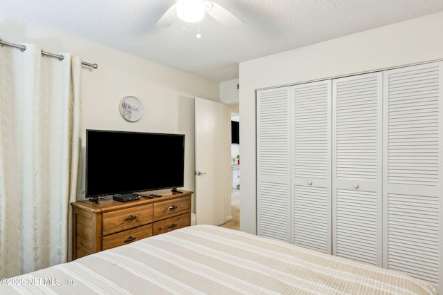 bedroom with a ceiling fan, a closet, and a textured ceiling