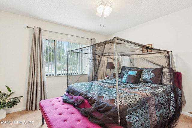 bedroom with a textured ceiling, carpet floors, and baseboards