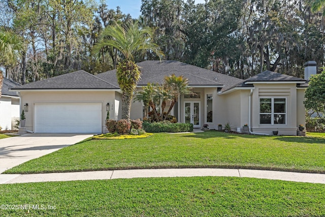 view of front of property with french doors, stucco siding, a garage, driveway, and a front lawn