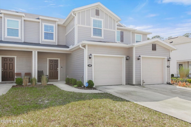 multi unit property with driveway, a front lawn, board and batten siding, and an attached garage