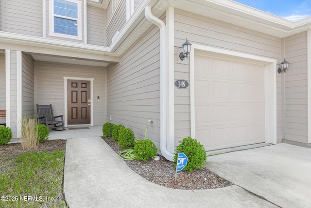 entrance to property featuring a garage and driveway