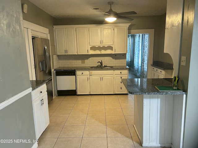 kitchen with backsplash, light tile patterned flooring, a sink, stainless steel fridge, and dishwasher