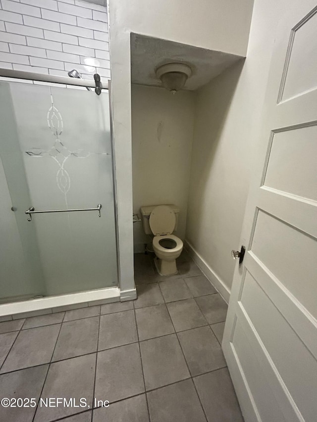 bathroom with tile patterned flooring, toilet, and baseboards