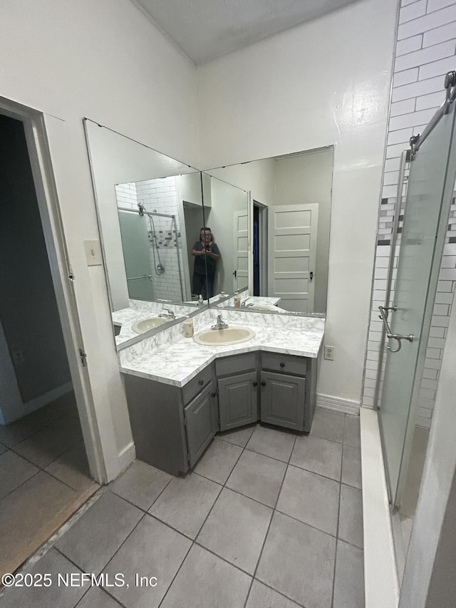 full bathroom featuring a stall shower, tile patterned flooring, vanity, and baseboards