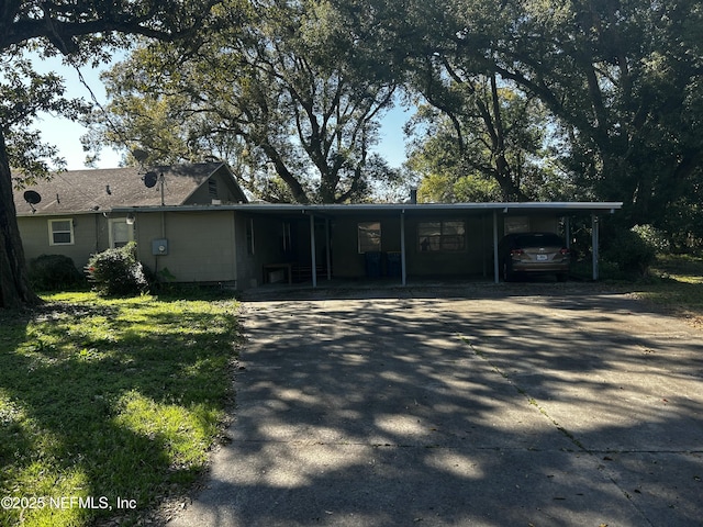 view of front of property featuring concrete driveway and a carport