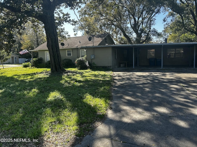 single story home with a carport, concrete driveway, and a front yard